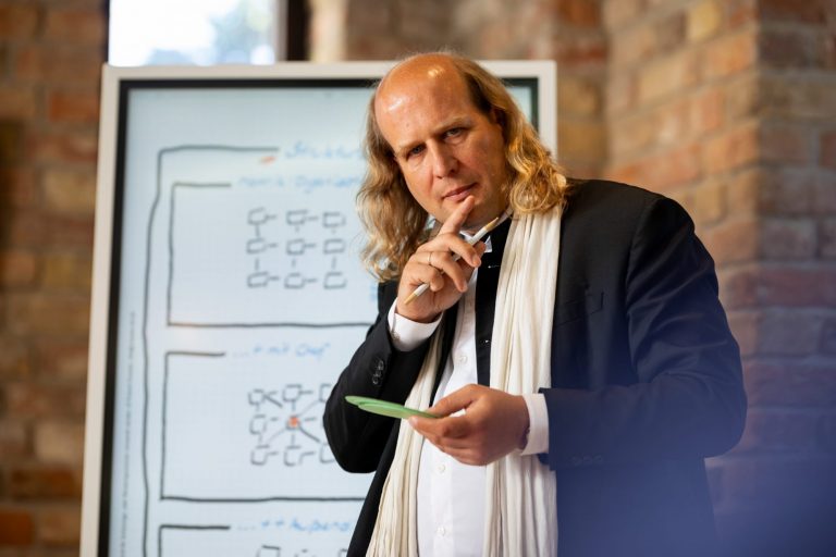 Roland Straube denkend vor Flip aus Modul Wirtschaft Mediationsausbildung